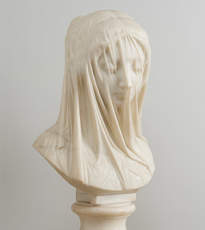 Marble sculpture of a head of a woman. Her eyes are downcast and the marble is carved into a veil over her face which does not obscure her features.