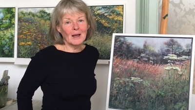 A woman stood next to an easel displaying a painting